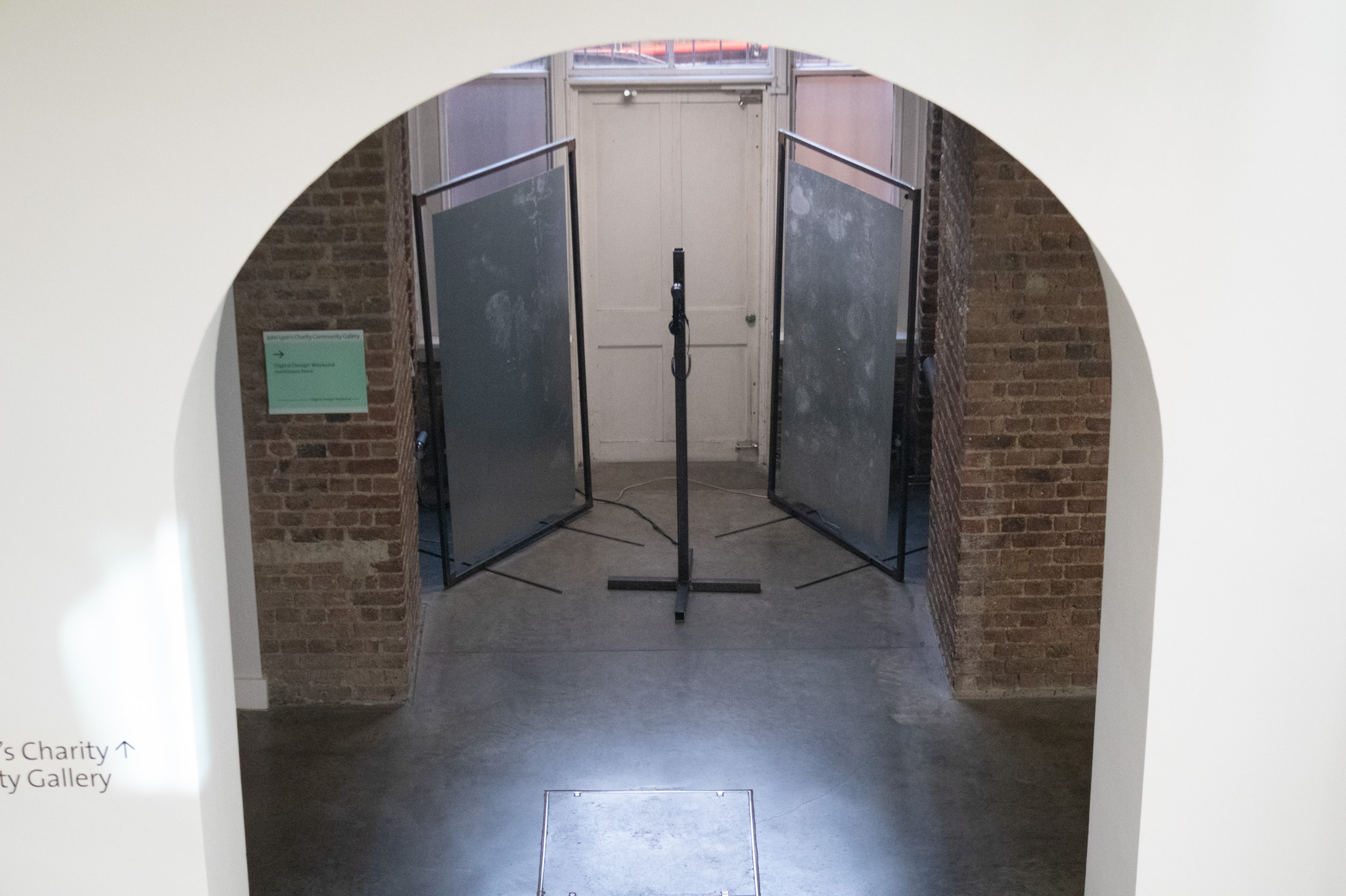 room with metal sheets and a central pole with a phone on it